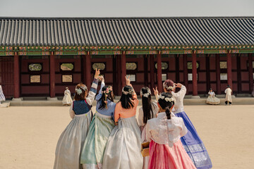 Korean girls in Hanbok or Korean dress. Young women having fun taking pictures in Gyeongbokgung Palace, tourism in korea.