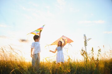 Wall Mural - Children running with kite in the field.