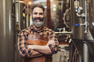 Portrait of man who is working at craft beer factory. Small family business, production of craft beer.