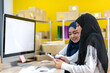 © Art_Photo - Muslim two asian woman freelancer sme business online shopping working and checklist order with cardboard box on table at home - Business online shipping and delivery concept