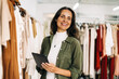 © (JLco) Julia Amaral - Happy boutique owner using a tablet to manager her shop