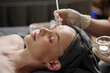 © DragonImages - Esthetician applying glycolic acid peel on face of young woman
