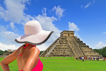 Woman in hat enjoying holidays at Kukulkan pyramid in Chichen Itza, Mexico.