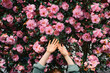 © Westend61 - Woman with arms raised in front of flowers
