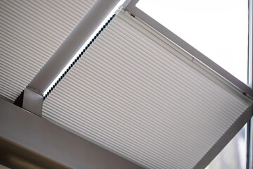 motorized pleated blinds on the roof windows. cellular pleated blinds for skylights, beige color. ho
