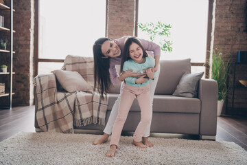 Sticker - Photo of cheerful funny mother daughter wear casual outfits having fun tickling together indoors house room