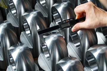 production quality control,
manufacturing.Hands of an engineer measures a metal part with a digital vernier caliper