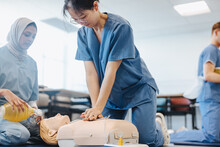 Medical Students Practicing CPR Techniques On A Manikin In Simulation Training