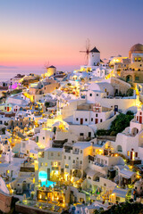 Wall Mural - Romantic evening view of traditional Greek village Oia on Santorini island in Greece. Santorini is iconic travel destination in Greece, famous of its sunsets and traditional white architecture.