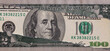 100 dollar banknote through torn 2 dollar banknote