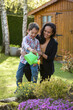 © AUFORT Jérome - young boy watering flowers with his mother