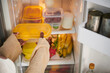 © DragonImages - Woman taking plastic container with fresh fruits from fridge