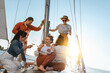 © blackday - Group of happy friends drinking wine and relaxing on the sailboat during sailing in sea