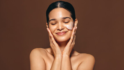 Wall Mural - Woman with smooth skin enjoys using a hydrogel patch on her skin, an undereye mask used for anti-aging