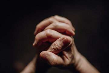 Close up of wrinkled praying hands, copy space.