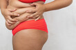 © Юля Бурмистрова - Cropped fat, adipose woman in red underwear squeezing dozed flabs sides on belly on white background. Excess overweight, need plastic surgery and liposuction. Subcutaneous fat problem. Copy space
