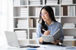© PaeGAG - Young smart Asian businesswoman with glasses writing her idea while working in her office room.
