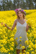Girl with a wreath in a rapeseed field