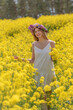 Girl with a wreath in a rapeseed field
