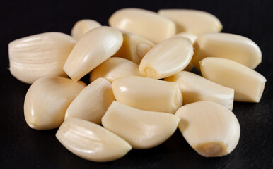 Wall Mural - Garlic cloves. Raw garlic isolated on black background. Vegetable