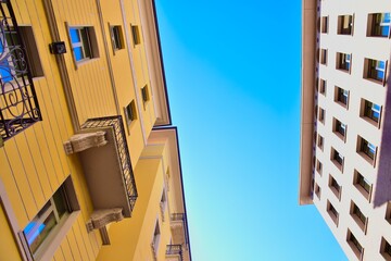 two old buildings stand side by side on the background of the blue sky 