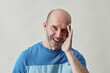 © Seventyfour - Minimal portrait of smiling bald man looking at camera in studio against white background
