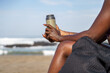© Jovo Jovanovic/Stocksy - Woman holding a flask sitting at the beach