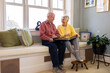 © Raymond Forbes LLC/Stocksy - Senior Citizen couple retired  at home laugh at family photo album