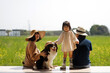 © ChaoShu Li/Stocksy - Asian family of three and pet dog are playing by rapeseed field