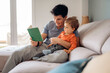 © Santi Nuñez/Stocksy - Dad teaching his son how to read