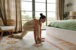 © Mihajlo Ckovric/Stocksy - Woman doing yoga at home