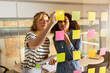 © BONNINSTUDIO/Stocksy - Business professionals brainstorming using adhesive notes in office