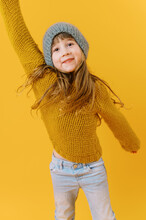 Happy Little Girl In Yellow Knit Sweater On Yellow Background