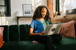 © Léa Jones/Stocksy - smiling young woman working on laptop