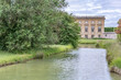 Marie Antoinette's Chateau, Le Petit Trianon, in Versaille, France, past a creek defocused in the foreground.