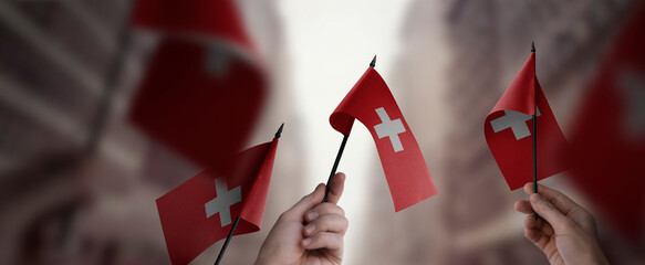 Wall Mural - A group of people holding small flags of the Switzerland in their hands