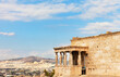 Greece. Acropolis of Athens. View of famous porch with six caryatid statues supporting architrave of Erechtheion against backdrop of Athens city and blue sky. Summer travel and excursions concept