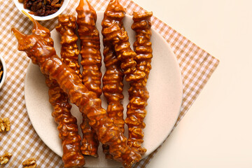 Wall Mural - Plate with tasty churchkhela on light background, closeup