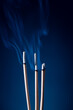 © Powerbank - Incense sticks and incense stick smoke on black backgrond with white backlit