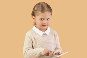 Wall Mural - Funny little businesswoman using tablet computer on beige background