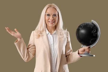 Wall Mural - Mature Geography teacher with globe on green background