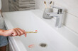 Blood on toothbrush on background of sink. Selective focus on the toothbrush.