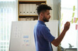 © DragonImages - Businessman writing figures on sticky notes to remember data from report