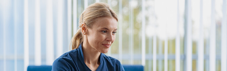 Sticker - Smiling doctor working laptop during appointment in her medical office