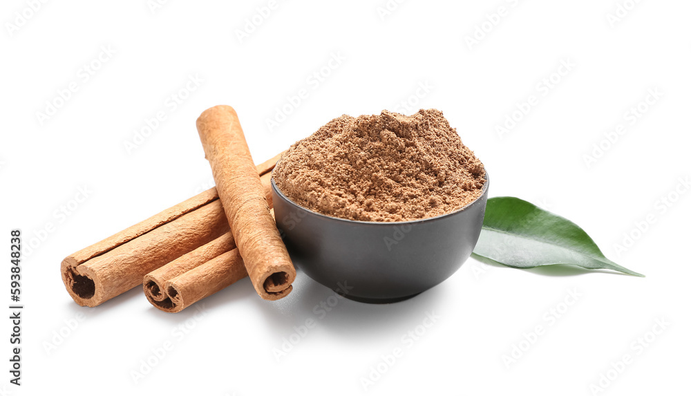 Bowl of powder with cinnamon sticks and leaf on white background