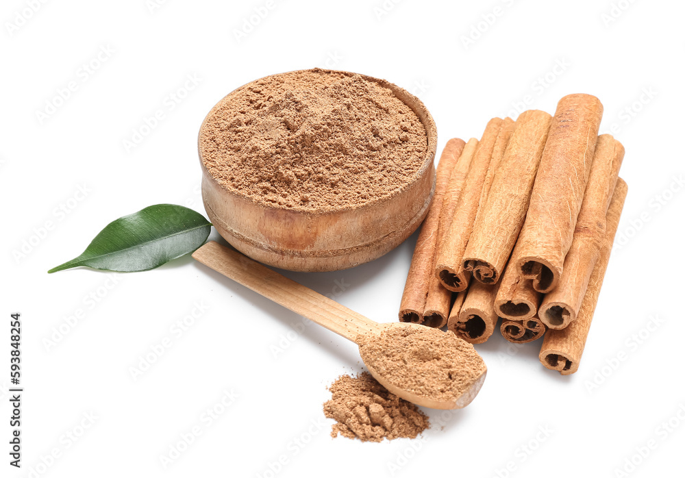 Bowl of powder with spoon and cinnamon sticks on white background