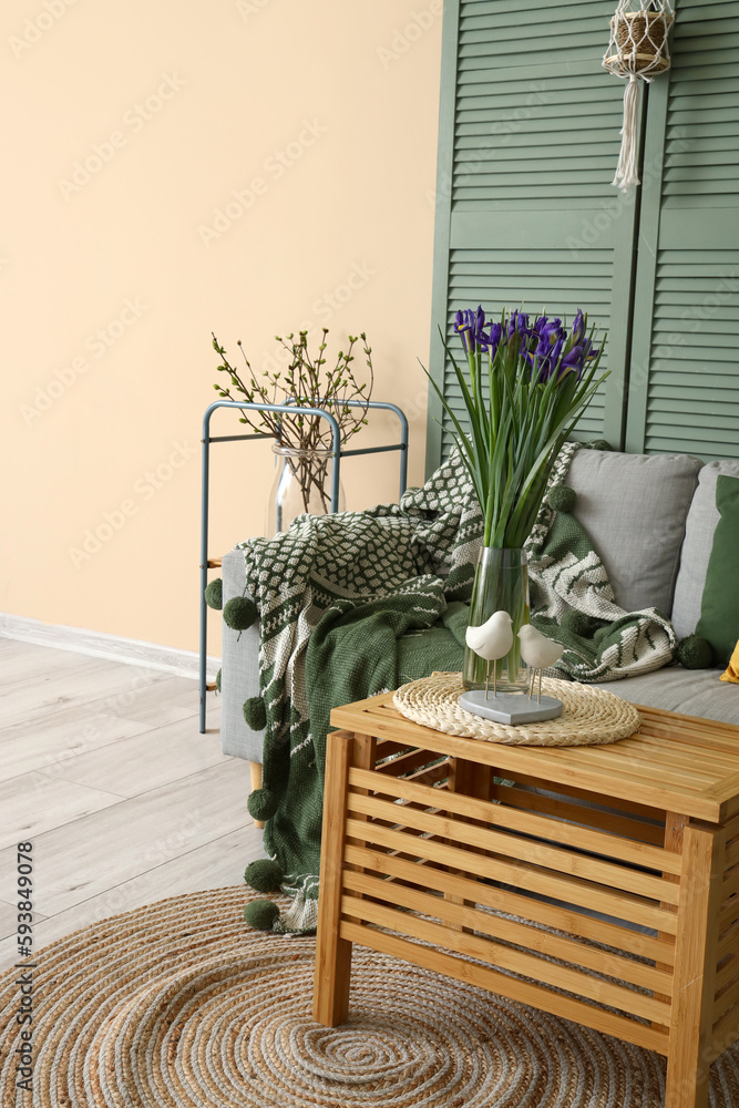 Interior of living room with grey sofa, table and folding screen