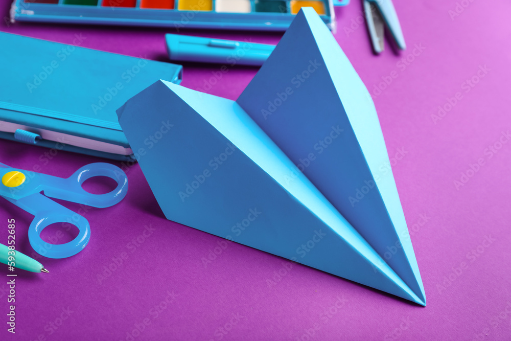 Composition with stationery supplies and paper planes on purple background