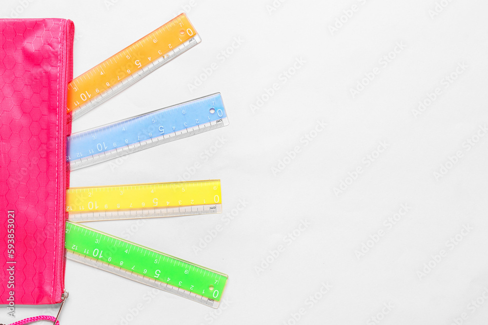 Colorful rulers on pink background