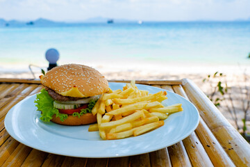 lunch at the beach of Koh Kradan island in Thailand with thai food and hamburg with french fries